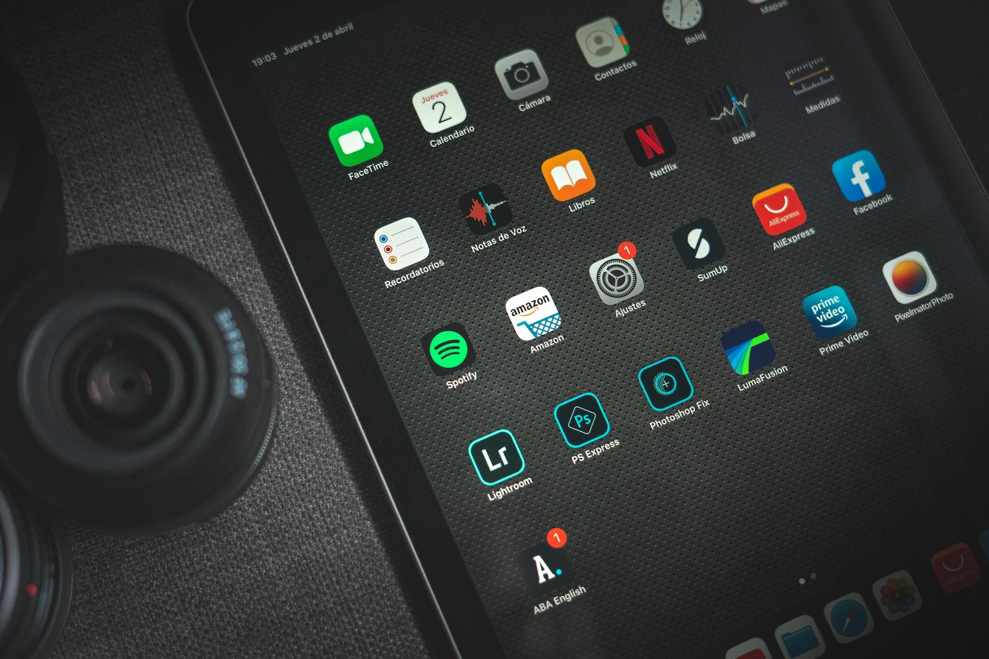Tablet displaying app icons on a textured fabric surface.